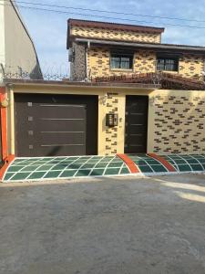 a house with two garage doors on a street at THE LANDING LODGE-ABIDJAN in Abidjan