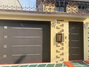 dos puertas de garaje en el lateral de un edificio en THE LANDING LODGE-ABIDJAN, en Abiyán