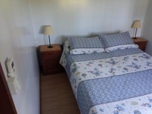 a small bedroom with a bed and two night stands at Nuestro sueño 2 in Colonia del Sacramento