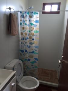 a bathroom with a toilet and a shower curtain at Nuestro sueño 2 in Colonia del Sacramento