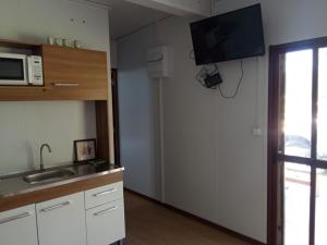 a kitchen with a sink and a microwave at Nuestro sueño 2 in Colonia del Sacramento