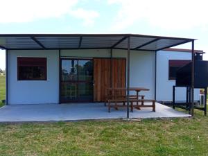 a building with a picnic table and a bench at Nuestro sueño 2 in Colonia del Sacramento