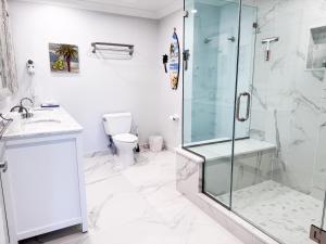 فندق أكوا بيتش في وايلدوود كريست: حمام مع دش زجاجي ومرحاض