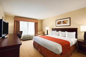 a hotel room with a large bed and a television at Country Inn & Suites by Radisson, Clinton, IA in Clinton