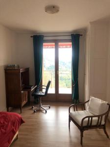 a bedroom with a window and a desk and chairs at NOUVEAU! Dans résidence Alexandra House in Leysin