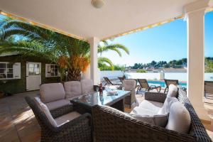 莫萊拉的住宿－Villa Malibu - PlusHolidays，庭院配有柳条家具和桌椅
