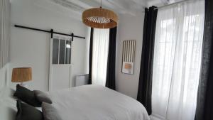 a bedroom with a bed and a large window at Maison Charmeilles - Le studio Canon de Fronsac in Fronsac