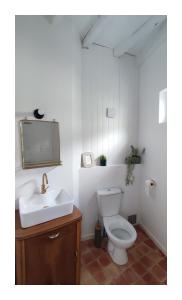 a bathroom with a white toilet and a sink at Maison Charmeilles - Le studio Canon de Fronsac in Fronsac