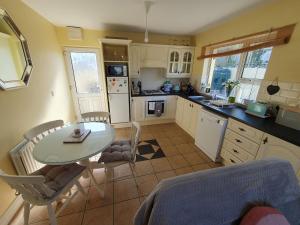 a kitchen with a table and a table and chairs at Quiet 2-Bedroom Buncrana Home in Buncrana
