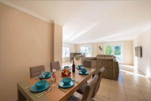 a dining room with a table and chairs and a couch at Villa Malibu - PlusHolidays in Moraira