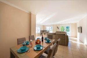 Un comedor con una mesa y sillas y un sofá. en Villa Malibu - PlusHolidays, en Moraira