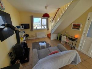 a living room with a couch and a staircase at Quiet 2-Bedroom Buncrana Home in Buncrana