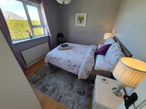 een kleine slaapkamer met een bed en een raam bij Quiet 2-Bedroom Buncrana Home in Buncrana