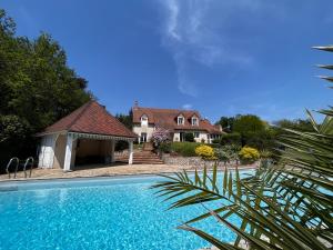 una casa y una piscina frente a una casa en Villa avec piscine à 10 min du circuit des 24h du Mans en Spay