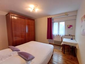a small bedroom with two beds and a window at Plain pied en rez de jardin à la campagne et proche de l'océan in Mahalon