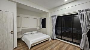 a bedroom with a bed and a large window at Coastal Paradise in Alibaug