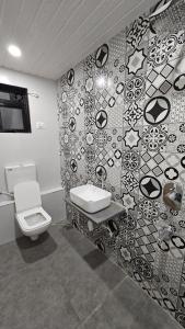 een badkamer met een toilet en een wastafel aan de muur bij Coastal Paradise in Alibaug