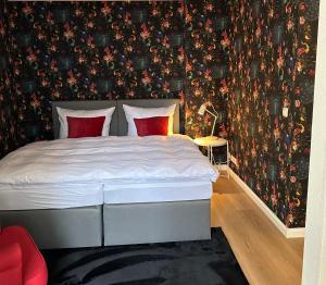 Schlafzimmer mit einem Bett mit Blumentapete in der Unterkunft Das Haus zur Rothen Thür 2 in Arnstadt