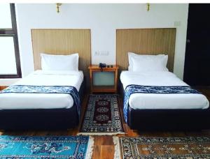 two beds in a room with two rugs at Himalayan Star Resort in Paro