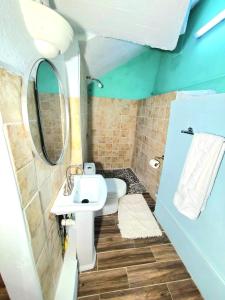 a bathroom with a white sink and a mirror at Beachfront Cozy Apt in Gros Islet