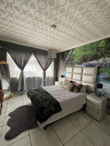 a bedroom with a large bed and a ceiling at P&l exclusive beauty parlour in Johannesburg