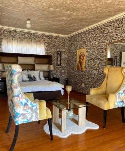 a bedroom with a bed and a table and chairs at P&l exclusive beauty parlour in Johannesburg