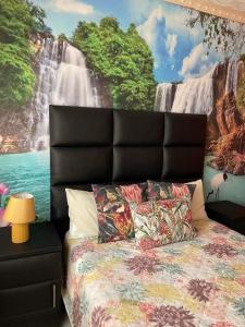 a bedroom with a large waterfall mural behind a bed at P&l exclusive beauty parlour in Johannesburg