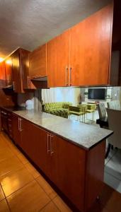 Una cocina con gabinetes de madera y encimera. en P&l exclusive beauty parlour, en Johannesburgo 5 fotos más