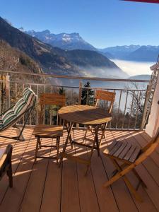 a wooden table and chairs on a deck with a view at NOUVEAU! Dans résidence Alexandra House in Leysin