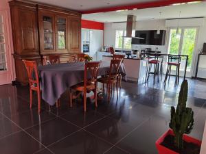 cocina y comedor con mesa y sillas en Villa avec piscine à 10 min du circuit des 24h du Mans en Spay