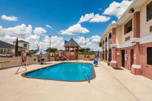 a swimming pool in the courtyard of a building at Studio 6 Suites Brenham, TX in Brenham