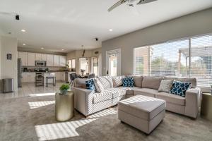 a living room with a large couch and a kitchen at Spacious Scottsdale Home with Private Heated Pool in Scottsdale