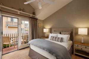 a bedroom with a bed and a balcony at Pelican Inn & Suites in Cambria