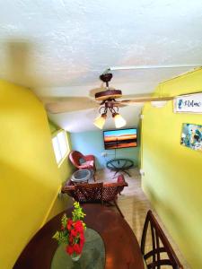 a living room with a table and a ceiling fan at Beachfront Cozy Apt in Gros Islet
