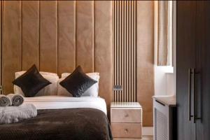 a bedroom with a bed with a wooden headboard at Luxury 4 Bed Knights Bridge in London