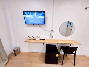 a room with a desk with a television on a wall at Matcha House jomtien Pattaya in Jomtien Beach