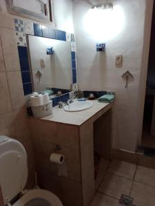 La salle de bains est pourvue d'un lavabo, de toilettes et d'un miroir. dans l'établissement casaglo, à Maimará