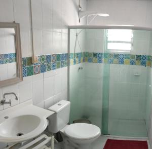 y baño con aseo, lavabo y ducha. en Residencial Praia da Daniela, en Florianópolis