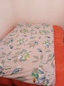 Una cama con una sábana con flores. en Apartman Old Town 2, en Stolac