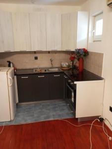 una pequeña cocina con armarios blancos y fregadero en Apartman Old Town 2, en Stolac