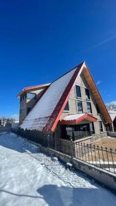 un edificio con techo rojo en la nieve en Cabaña Alpina, en Creel