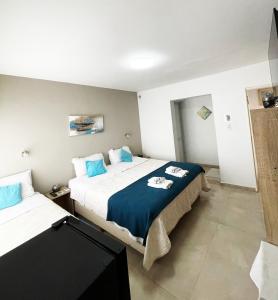 a bedroom with two beds and a tv in it at Hotel Boutique in Mina Clavero