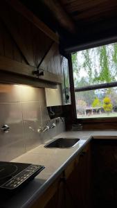 cocina con fregadero y ventana en Cabaña Suiza en Cacheuta