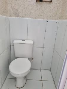 des toilettes blanches dans une salle de bain carrelée blanche dans l'établissement Studio - 200m do Pré caju, à Aracaju