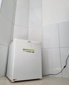 - un réfrigérateur blanc installé à côté d'un mur en carrelage blanc dans l'établissement Studio - 200m do Pré caju, à Aracaju