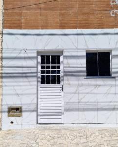 Studio - 400m da orla في أراكاجو: مبنى ابيض بباب ونافذة