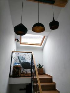 una escalera con tres luces, una ventana y una silla en Lukova hiša- Luka's house, en Vipava