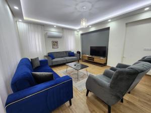 ein Wohnzimmer mit blauen Sofas und einem Flachbild-TV in der Unterkunft Villa Sunset in Dalyan