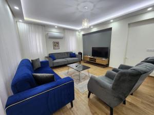 a living room with blue couches and a flat screen tv at Villa Sunset in Dalyan