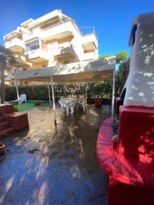 um edifício com uma mesa e um guarda-chuva branco em Seashell Guest House em Santa Marinella